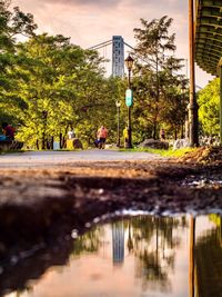 Reflection of people walking on puddle in city