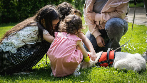 Portrait of children playing with a dog in the park.