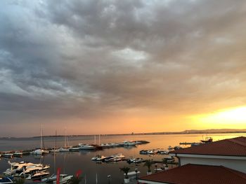 Boats moored at harbor during sunset