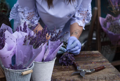 Midsection of woman making bouquet at flower shop