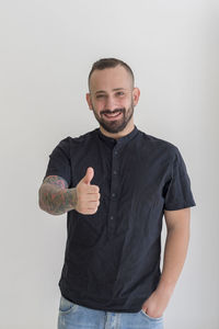 Portrait of young man standing against white background