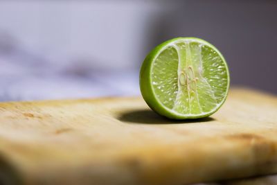 Close-up of green lemon on cutting board