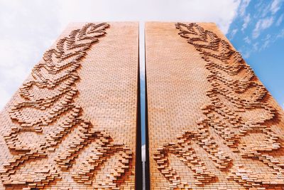 Low angle view of carving on wood against sky