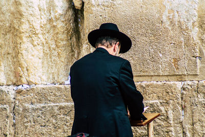 Rear view of man standing against wall