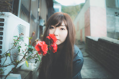 Portrait of woman with red flowers