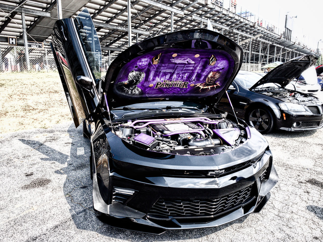 mode of transportation, transportation, land vehicle, day, motor vehicle, no people, car, sunlight, architecture, outdoors, city, nature, built structure, stationary, abandoned, damaged, obsolete, junkyard, street, building exterior, wheel, purple, ruined, garage