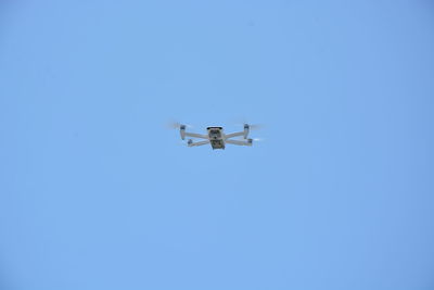 Low angle view of airplane against clear blue sky