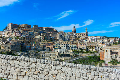 Buildings in city against blue sky