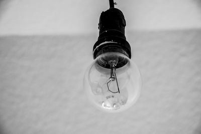 Close-up of light bulb hanging from water