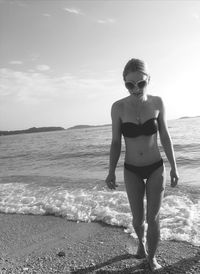 Full length of young woman standing on beach