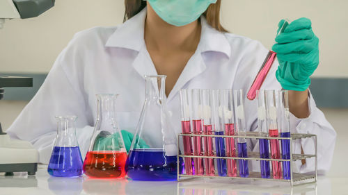 Midsection of scientist doing experiment at laboratory