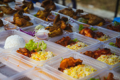  street stall nasi ayam tomato packed in bio degradable plastic container .