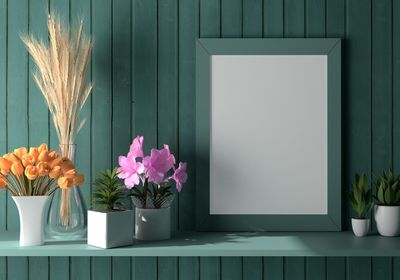 Close-up of potted plants on table against wall