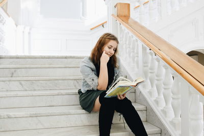 Young student reading on stairs