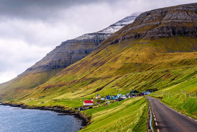 Scenic view of road by mountains against sky