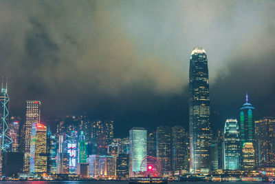 Illuminated buildings in city against sky