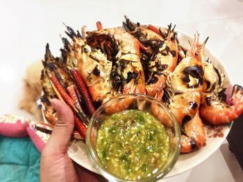 Close-up of hand holding food in plate