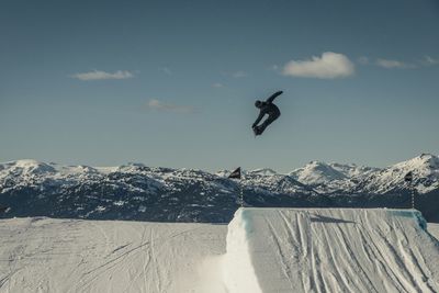 Low angle view of person skiing on mountain against sky