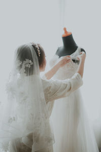 Rear view of woman holding her wedding dress