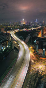 High angle view of illuminated street amidst buildings at night