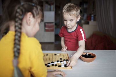 Cute kids playing board game at home