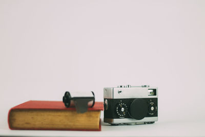 Close-up of camera on table against white background