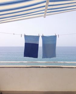 Close-up of clothes drying on sea against sky