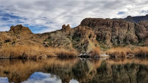 Scenic view of lake by mountain against sky