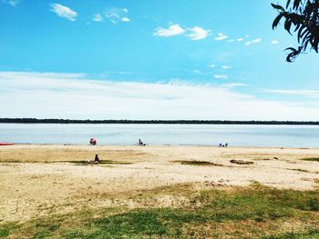 Scenic view of lakeshore against blue sky