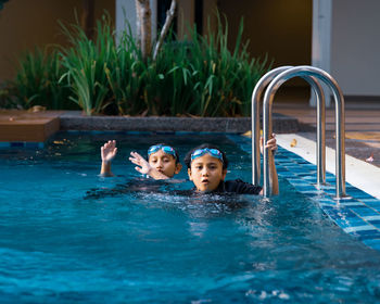 Portrait of boy with girl in swimming in pool