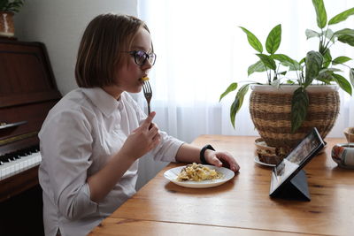 Woman sitting on table at home