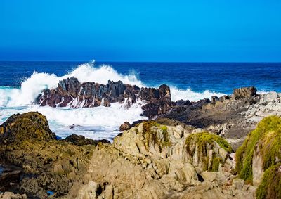 Panoramic shot of rocks on beach against sky