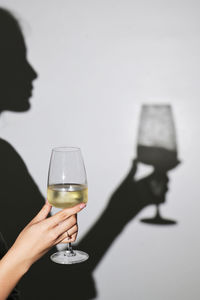 Abstract woman shadow and white wine glass