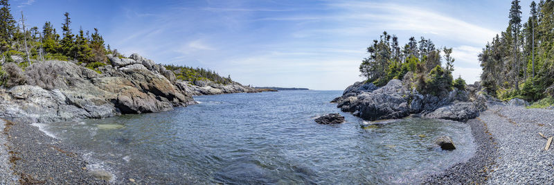 Panoramic shot of rocks by sea against sky