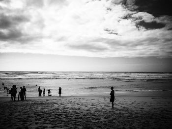 People on beach against sky