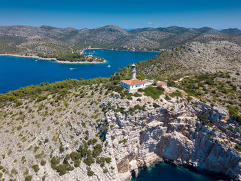 Scenic view of sea by buildings against blue sky