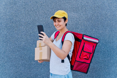 Portrait of smiling young man holding mobile phone