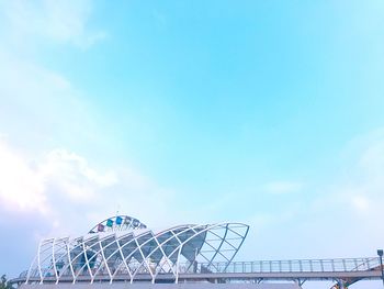 Low angle view of ferris wheel against cloudy sky