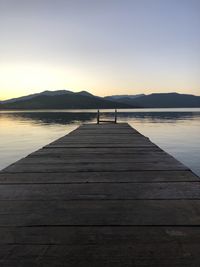 Pier over lake against sky during sunset