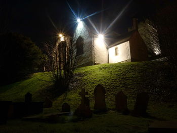 Illuminated cemetery against sky at night