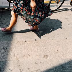 Low section of woman walking on footpath