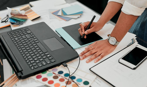 Midsection of man using laptop on table
