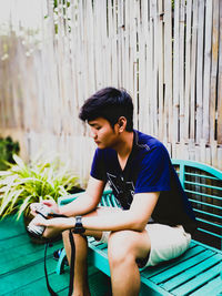 Young man looking away while sitting on bicycle