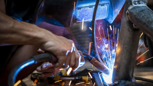 Welding of steel, sparking, not wearing gloves, light colored like fireworks.