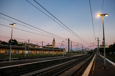 Railroad tracks against sky during sunset