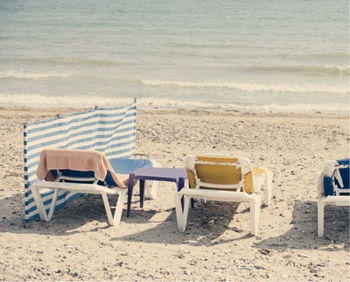 Rear view of lounge chairs on beach