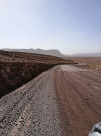 Road amidst desert against clear sky