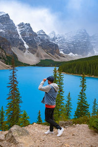 Full length of man standing on lake by mountains