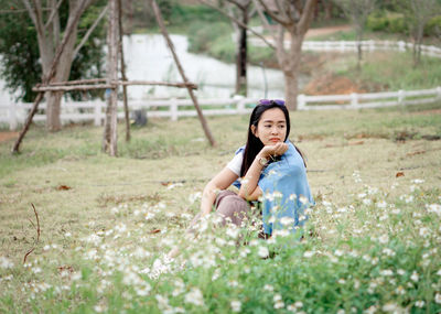 Portrait of young woman sitting on field