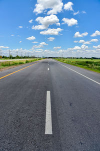 Empty road on field against sky